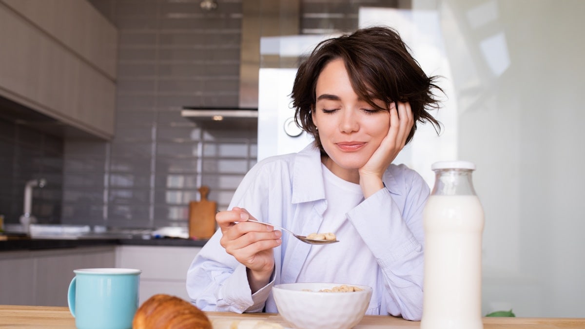 a woman sitting at a table with a plate of food