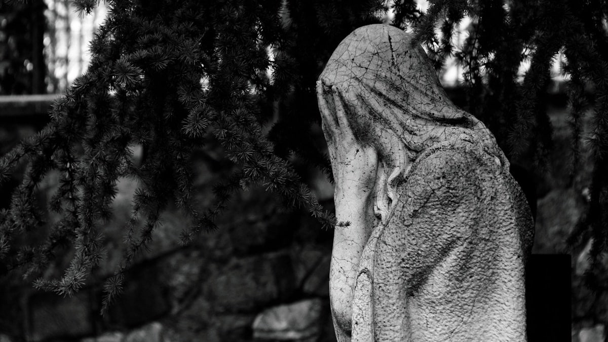 gray concrete statue near green trees during daytime