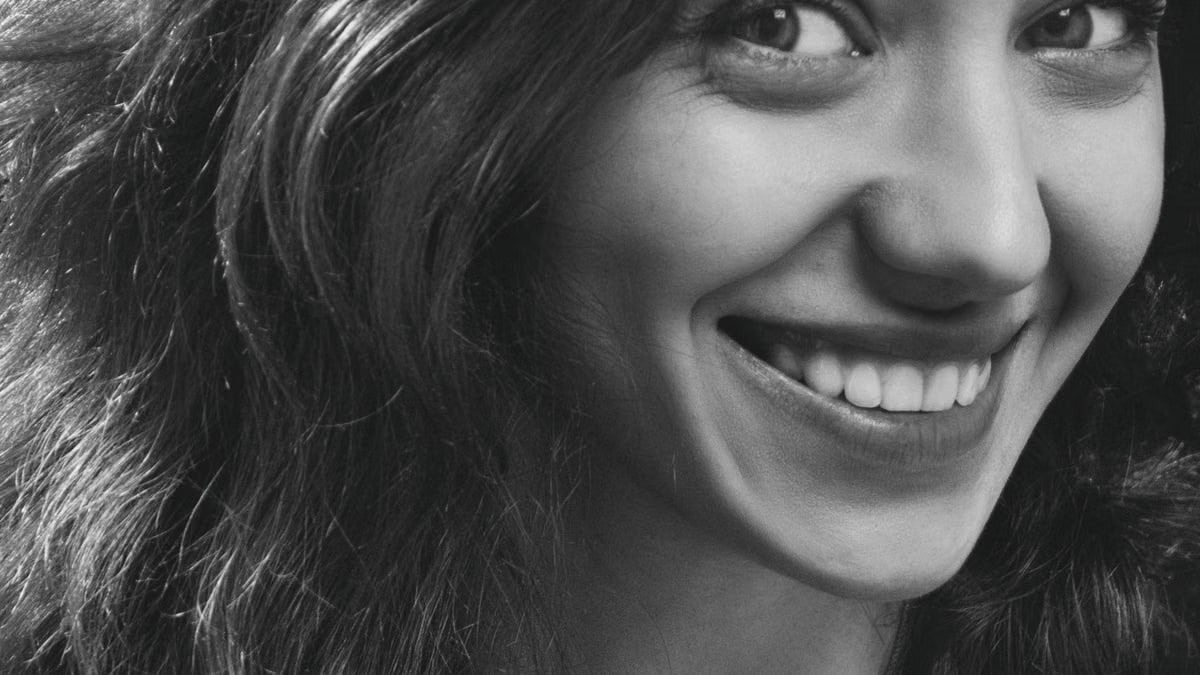 Close-up black and white portrait of a smiling woman with wavy hair in Kyiv.
